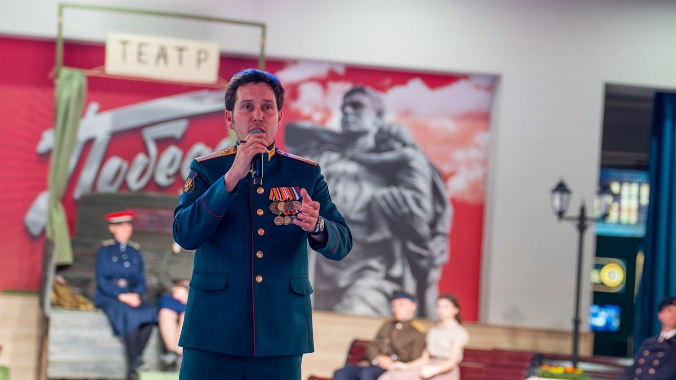 Исполнитель в военной форме с наградами поёт со сцены